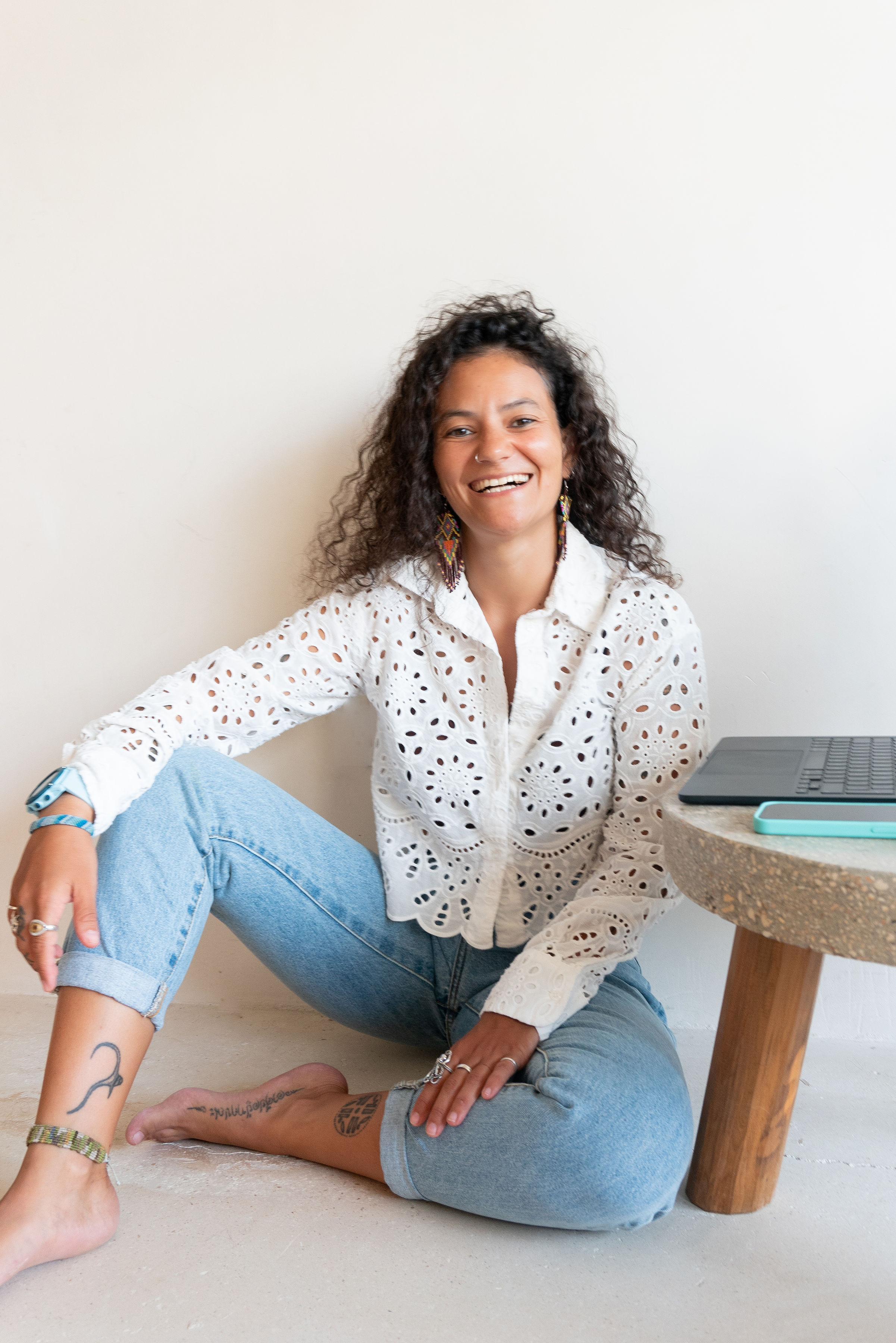 Leyla seated on the floor beside a laptop and table.